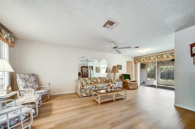 8420 Winding Wood Dr, Port Richey, FL 34668 - living room with arched walkways, visible vents, and wood finished floors