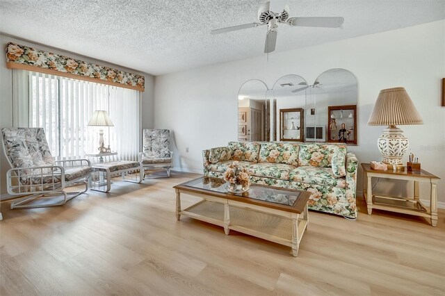 8420 Winding Wood Dr, Port Richey, FL 34668 - living area with a textured ceiling, wood finished floors, a ceiling fan, and baseboards