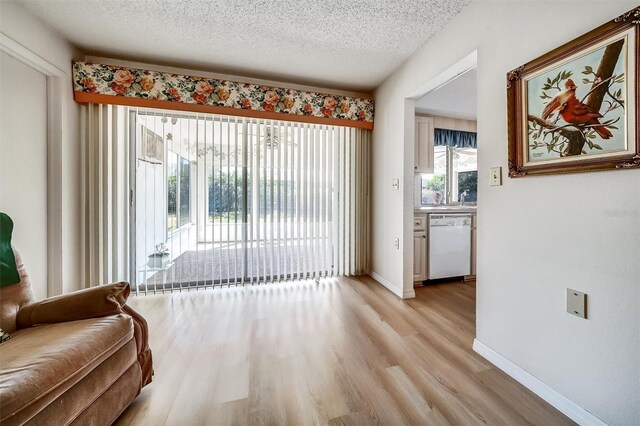 8420 Winding Wood Dr, Port Richey, FL 34668 - interior space featuring light wood-style floors, a textured ceiling, and baseboards