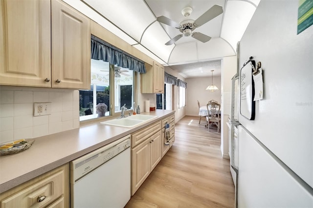 8420 Winding Wood Dr, Port Richey, FL 34668 - kitchen featuring light countertops, light brown cabinetry, a sink, light wood-type flooring, and white appliances