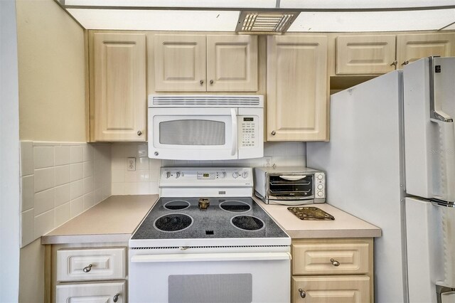 8420 Winding Wood Dr, Port Richey, FL 34668 - kitchen with white appliances, light brown cabinets, light countertops, and decorative backsplash