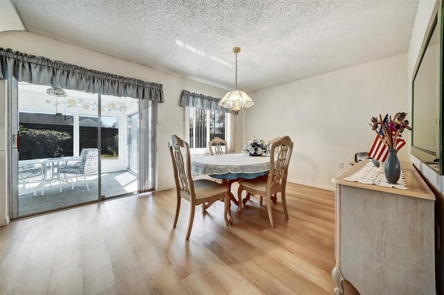 8420 Winding Wood Dr, Port Richey, FL 34668 - dining area featuring a textured ceiling, light wood-style flooring, and baseboards