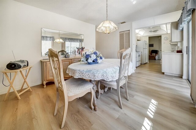 8420 Winding Wood Dr, Port Richey, FL 34668 - dining space featuring light wood-style flooring and visible vents