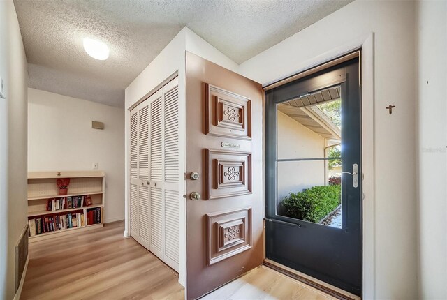 8420 Winding Wood Dr, Port Richey, FL 34668 - entryway with a textured ceiling and light wood-style floors