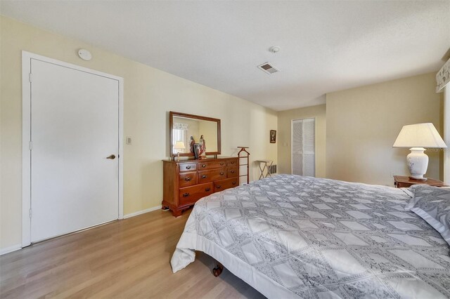 8420 Winding Wood Dr, Port Richey, FL 34668 - bedroom featuring visible vents, baseboards, and wood finished floors
