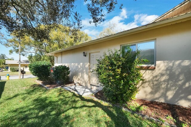 8420 Winding Wood Dr, Port Richey, FL 34668 - view of property exterior featuring stucco siding and a yard