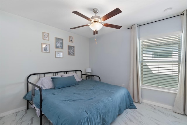 bedroom featuring marble finish floor, a ceiling fan, and baseboards