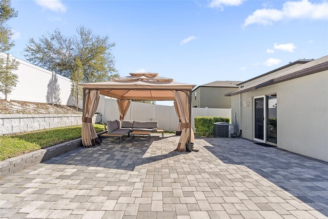 view of patio / terrace with outdoor lounge area, central AC unit, a gazebo, and a fenced backyard