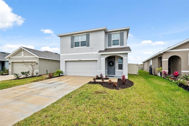 traditional-style house with an attached garage, concrete driveway, a front yard, and stucco siding