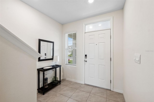 foyer featuring light tile patterned floors and baseboards