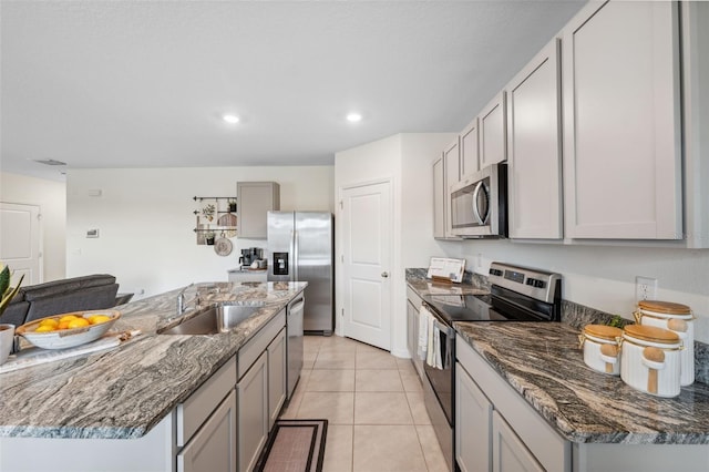 kitchen with light tile patterned floors, stainless steel appliances, recessed lighting, gray cabinetry, and a sink