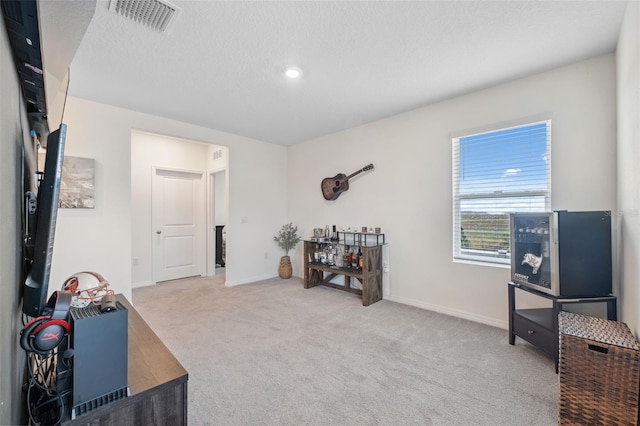 misc room featuring a textured ceiling, carpet floors, visible vents, and baseboards