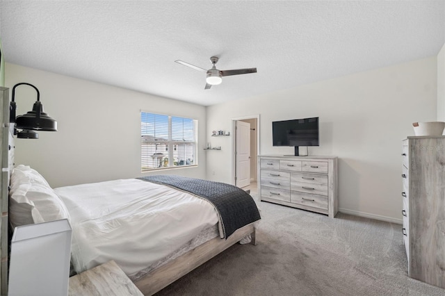 bedroom with carpet floors, a textured ceiling, baseboards, and a ceiling fan