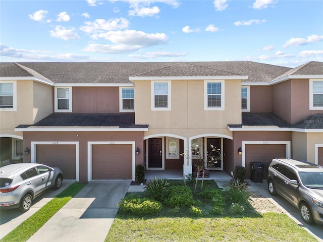 multi unit property with driveway, roof with shingles, and stucco siding