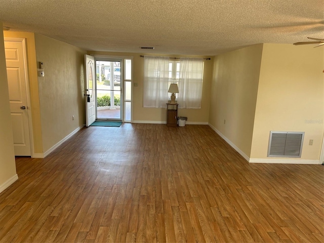 interior space with wood finished floors, visible vents, and baseboards