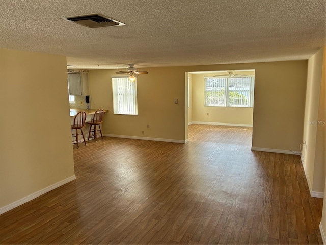 spare room featuring visible vents, baseboards, a ceiling fan, and wood finished floors