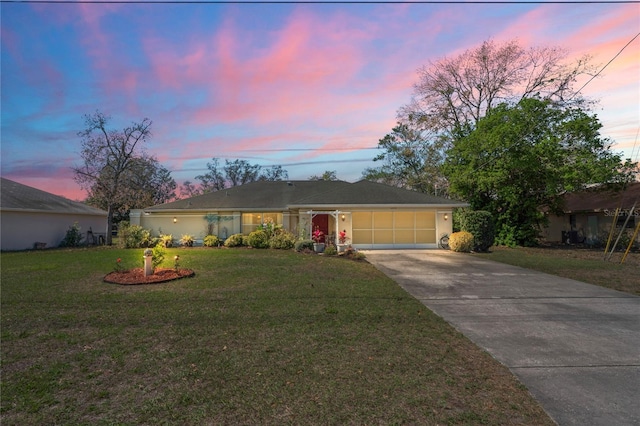 ranch-style house featuring a garage, concrete driveway, and a front yard