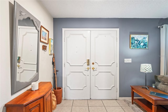 entrance foyer with a textured ceiling and light tile patterned floors