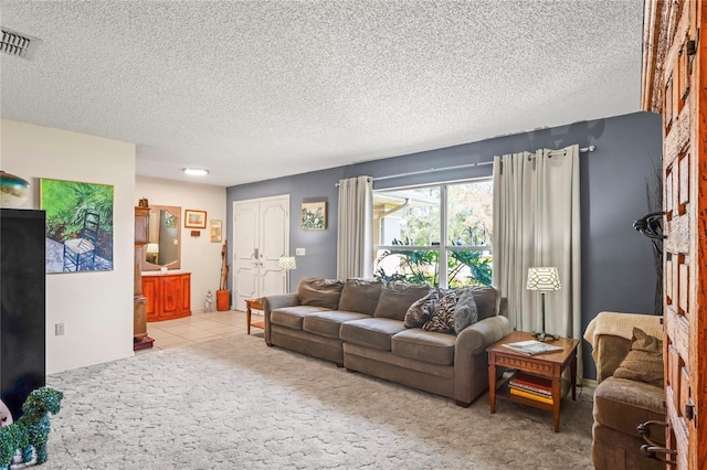 living area with tile patterned flooring, visible vents, and a textured ceiling