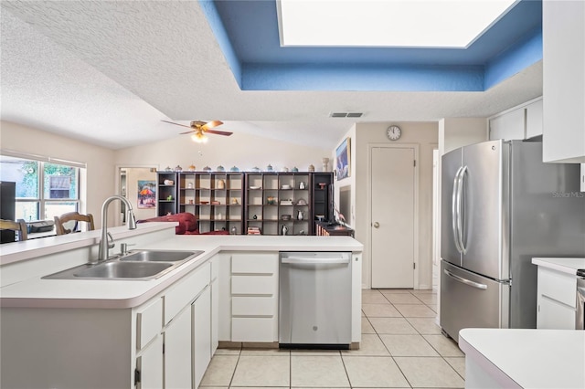 kitchen featuring light tile patterned floors, stainless steel appliances, a sink, visible vents, and light countertops