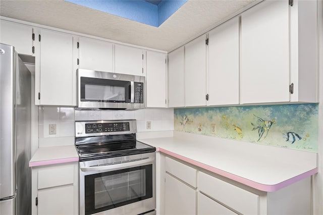 kitchen with stainless steel appliances, tasteful backsplash, light countertops, and white cabinets