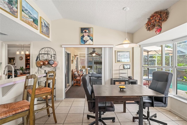 office area with baseboards, a sunroom, vaulted ceiling, a textured ceiling, and light tile patterned flooring