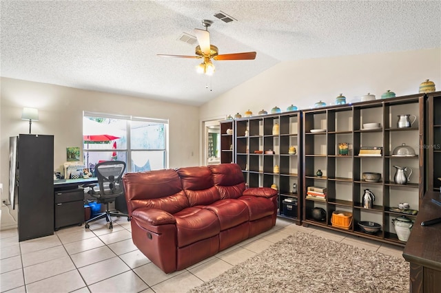 living area with vaulted ceiling, light tile patterned floors, a textured ceiling, and visible vents