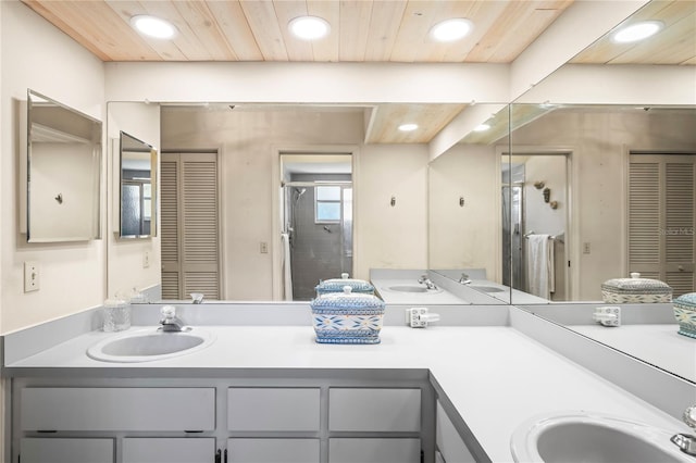 bathroom featuring double vanity, a closet, a sink, and a stall shower