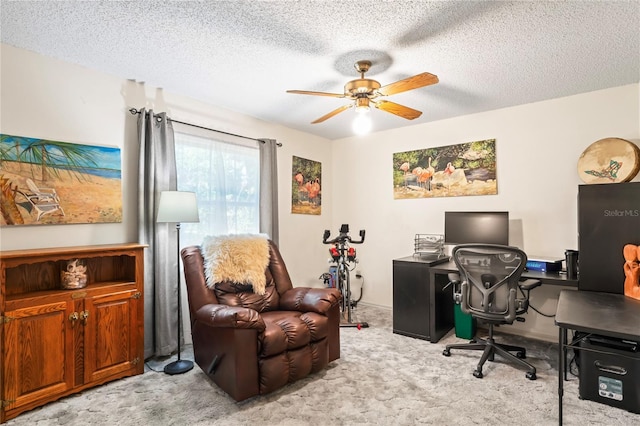 office featuring ceiling fan, a textured ceiling, and light colored carpet