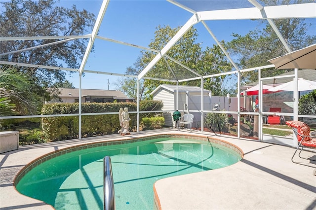 view of pool featuring an outbuilding, a patio, and a lanai