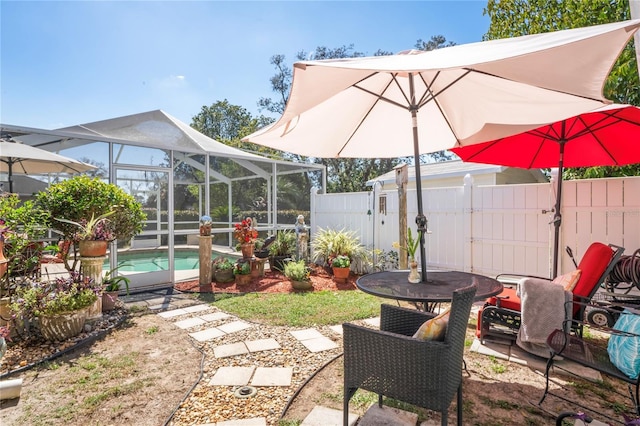 view of patio with glass enclosure, a fenced backyard, and a fenced in pool