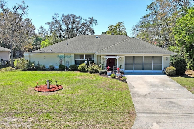 ranch-style home featuring an attached garage, roof with shingles, concrete driveway, and a front yard