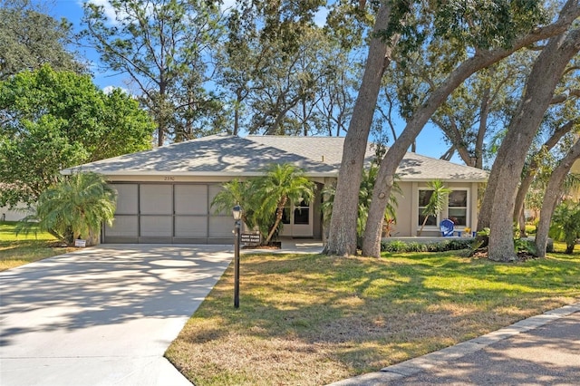 ranch-style home featuring a garage, concrete driveway, and a front lawn