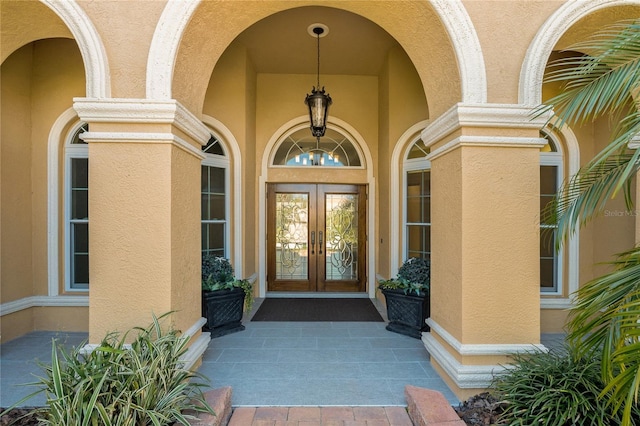 property entrance featuring french doors and stucco siding