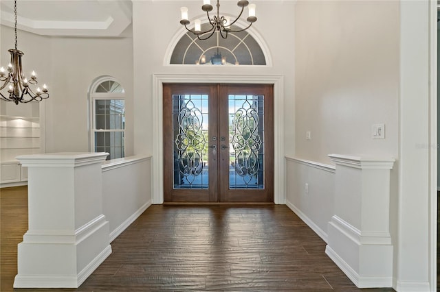 entryway featuring french doors, an inviting chandelier, and dark wood finished floors