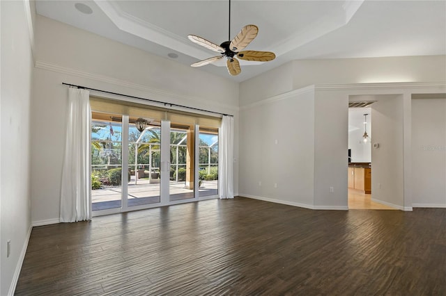 unfurnished room with a raised ceiling, wood finished floors, baseboards, and ceiling fan