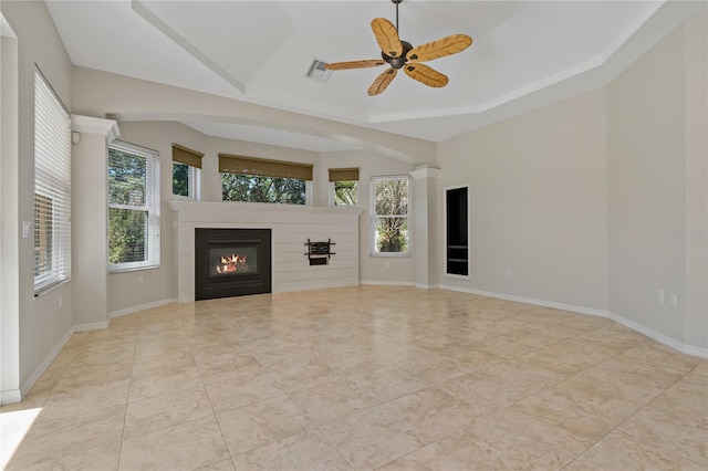 unfurnished living room with a glass covered fireplace, a healthy amount of sunlight, and baseboards