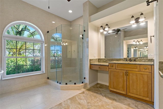 bathroom with baseboards, vanity, a shower stall, and a ceiling fan