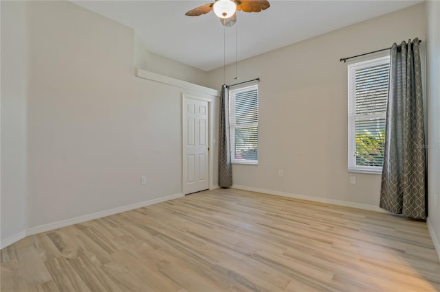 empty room featuring light wood-style floors, baseboards, and ceiling fan