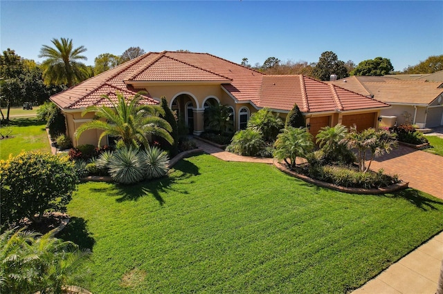 mediterranean / spanish-style home with a tile roof, decorative driveway, a garage, and a front yard