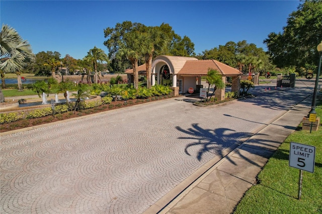 mediterranean / spanish home with a gate, stucco siding, and a tile roof