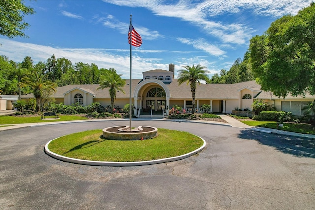 view of building exterior with curved driveway