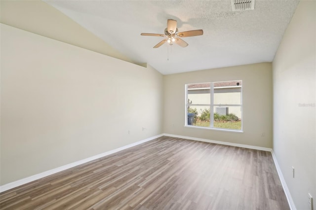 unfurnished room featuring baseboards, a textured ceiling, visible vents, and wood finished floors