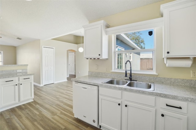 kitchen featuring white cabinets, light wood-style flooring, white dishwasher, light countertops, and a sink