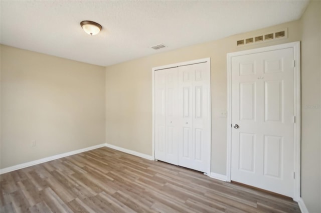 unfurnished bedroom with a closet, visible vents, and baseboards