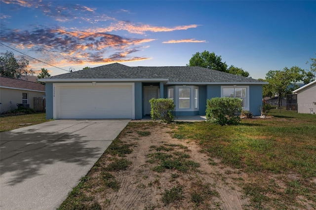 ranch-style home with an attached garage, a lawn, concrete driveway, and stucco siding