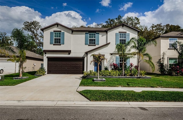 view of front of property featuring a front yard, concrete driveway, an attached garage, and stucco siding