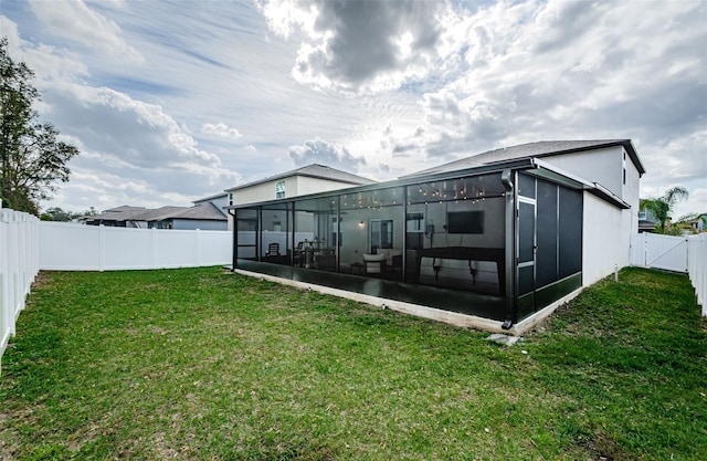 rear view of property featuring a sunroom, a fenced backyard, stucco siding, and a yard