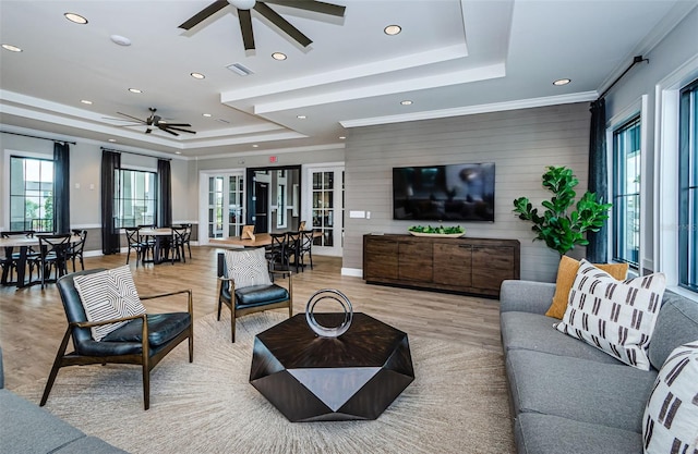 living area featuring ceiling fan, light wood-style flooring, recessed lighting, a tray ceiling, and crown molding