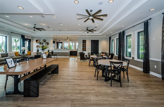 dining space with visible vents, a raised ceiling, wood finished floors, crown molding, and recessed lighting